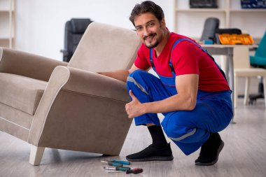 Genç erkek marangoz atölyede çalışıyor.