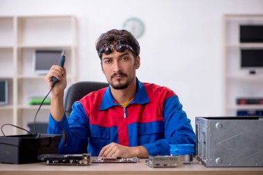 Bilgisayar tamir eden genç bir erkek tamirci.