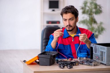 Bilgisayar tamir eden genç bir erkek tamirci.