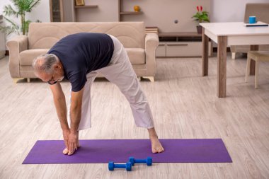 Yaşlı adam evde spor yapıyor.