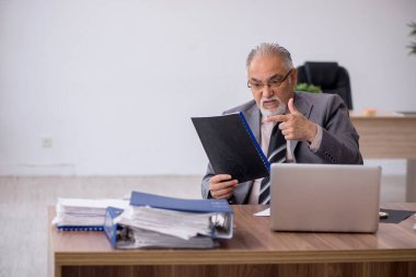 Ofiste çalışan yaşlı bir erkek.