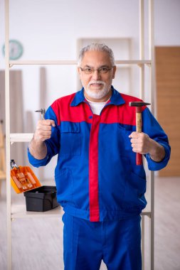 Yaşlı erkek marangoz içeride çalışıyor.