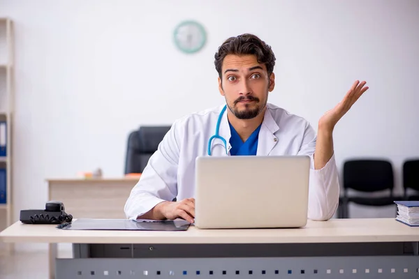 Jonge mannelijke arts werkzaam in de kliniek — Stockfoto