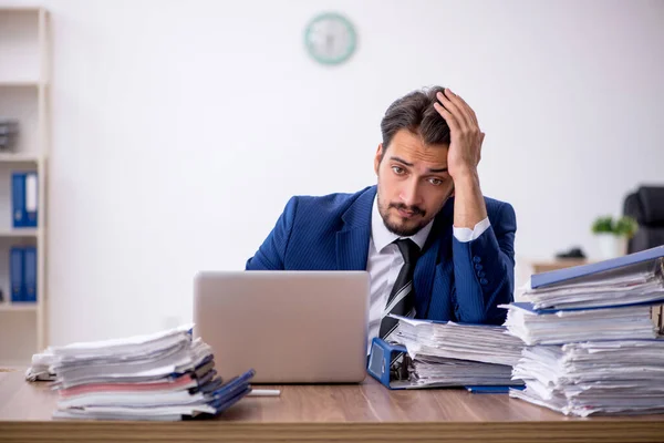 Jeune employé masculin et trop de travail au bureau — Photo