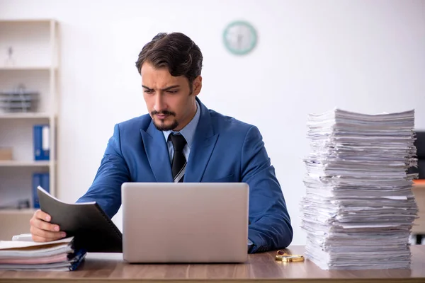 Jovem funcionário masculino infeliz com excesso de trabalho no escritório — Fotografia de Stock