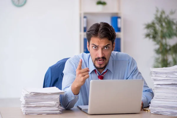 Jeune employé masculin et trop de travail au bureau — Photo