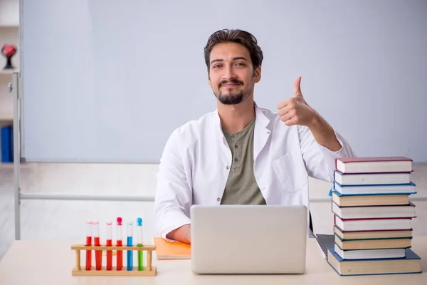 Jonge mannelijke scheikundige leraar in de voorkant van whiteboard — Stockfoto