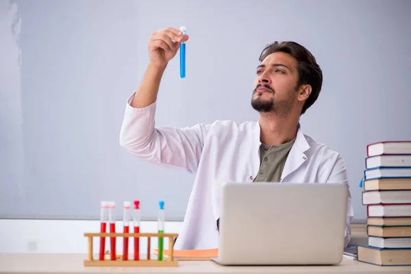 Jonge mannelijke scheikundige leraar in de voorkant van whiteboard — Stockfoto