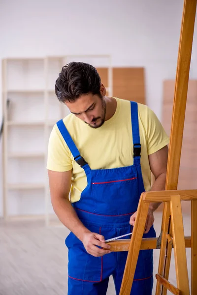 Jonge mannelijke reparateur repareert ezel thuis — Stockfoto