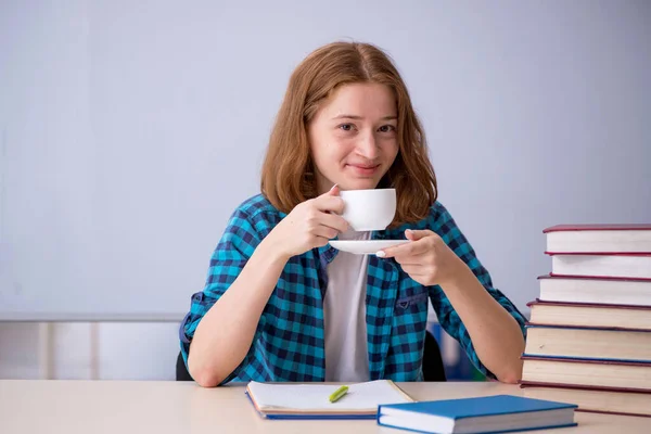 Молодая студентка пьет кофе во время перерыва — стоковое фото