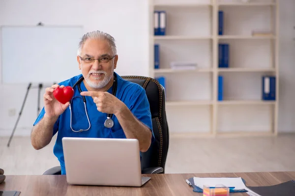 Old male doctor cardiologist working in the clinic — Stock Photo, Image