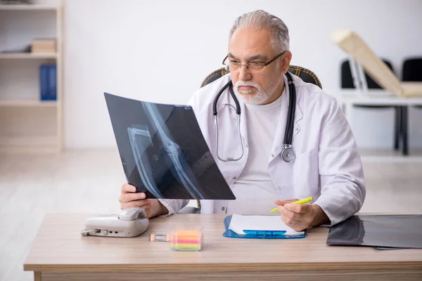 Klinikte çalışan yaşlı bir erkek radyolog. — Stok fotoğraf