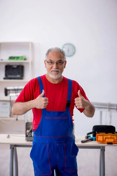 Vieux réparateur masculin à l'atelier — Photo