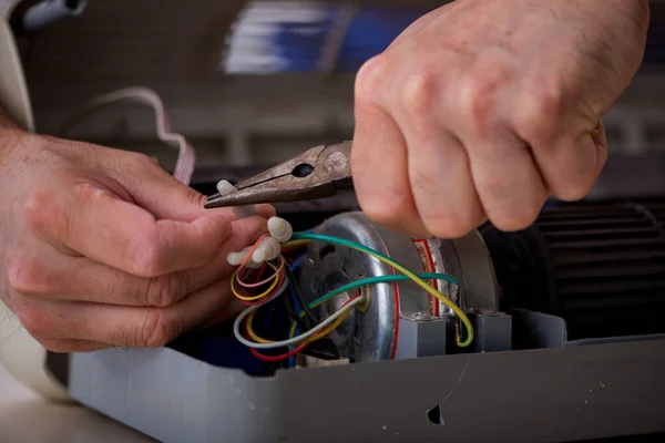 Old repairman repairing air-conditioner at workshop — Stock Photo, Image