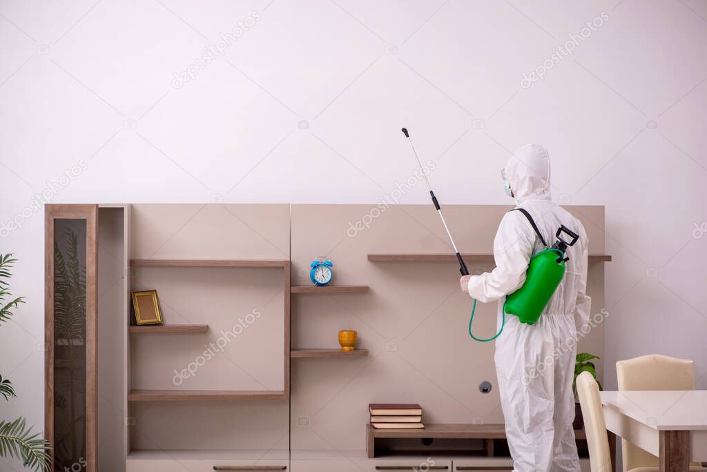Young male contractor doing pest control at home