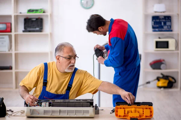 Dois reparadores do sexo masculino reparando ar ar condicionado — Fotografia de Stock