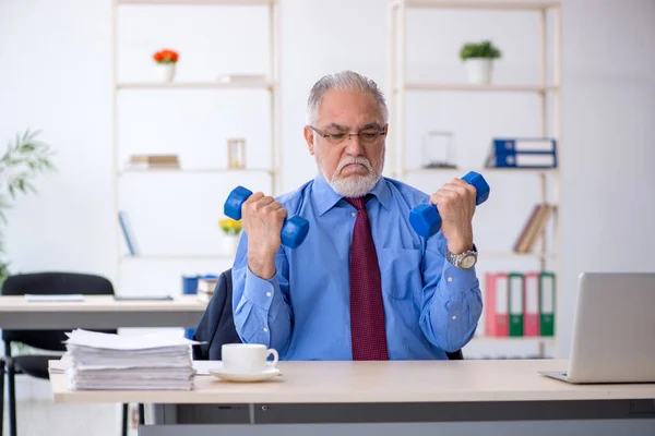 Gammal manlig anställd som motionerar under pausen — Stockfoto