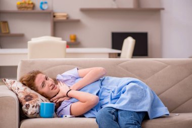 Evde acı çeken genç bir kadın.