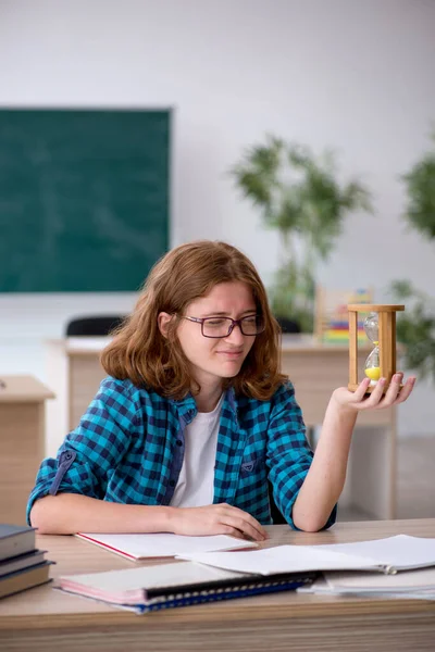 Jonge vrouwelijke student in time management concept — Stockfoto