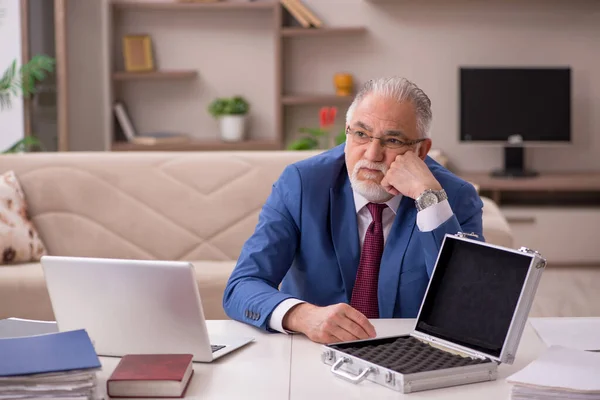 Old male employee and empty money case at home — Stock Photo, Image