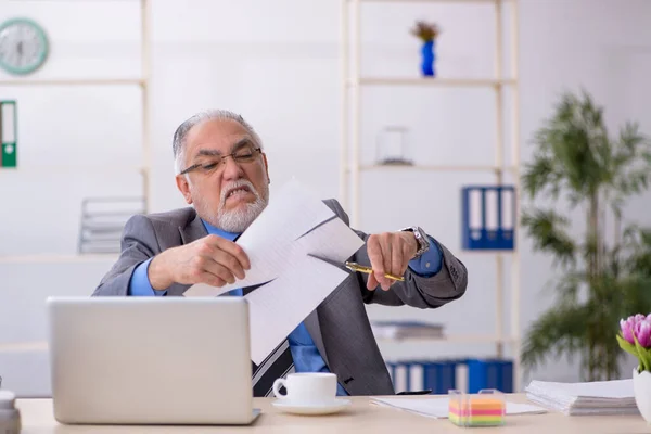 Starý zaměstnanec drží nůžky v kanceláři — Stock fotografie