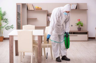 Young male contractor disinfecting at home