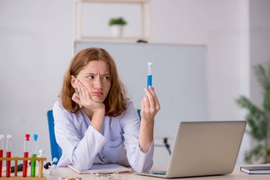 Laboratuarda çalışan genç bir kadın kimyager.