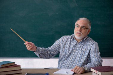 Sınıftaki yaşlı erkek öğretmen.