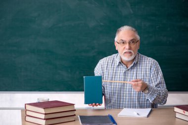 Sınıftaki yaşlı erkek öğretmen.