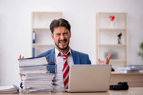 Junge männliche Mitarbeiter und zu viel Arbeit im Büro — Stockfoto