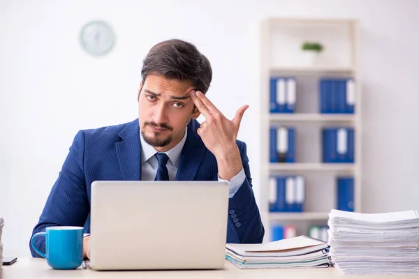 Jonge mannelijke werknemer en te veel werk op kantoor — Stockfoto