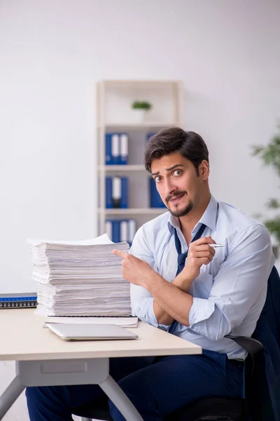 Jonge mannelijke werknemer en te veel werk op kantoor — Stockfoto