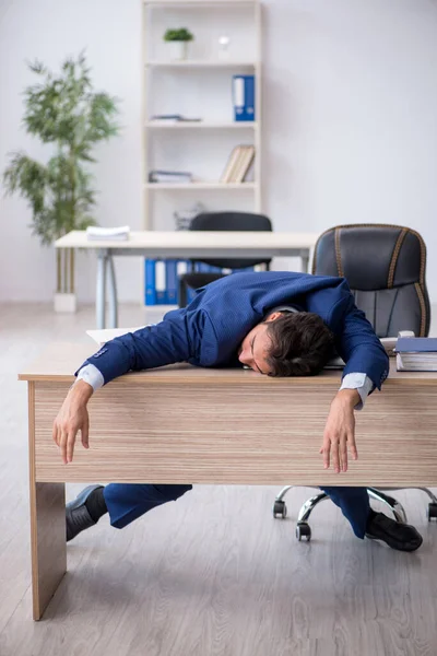 Joven empleado masculino extremadamente cansado en la oficina —  Fotos de Stock