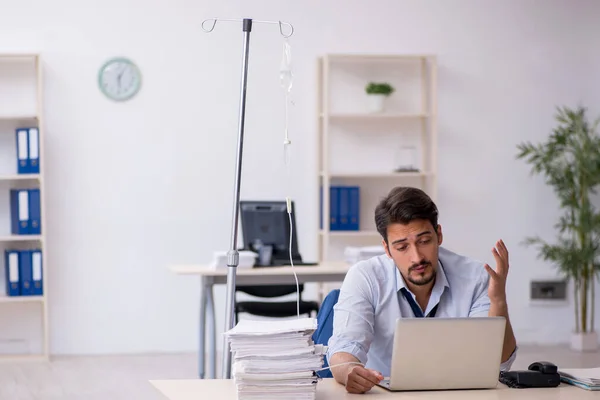 Giovane dipendente maschile che soffre sul posto di lavoro — Foto Stock