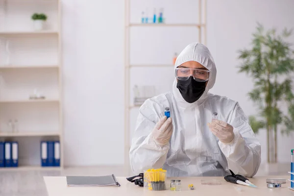 Jonge mannelijke chemicus werkt in het lab tijdens een pandemie — Stockfoto