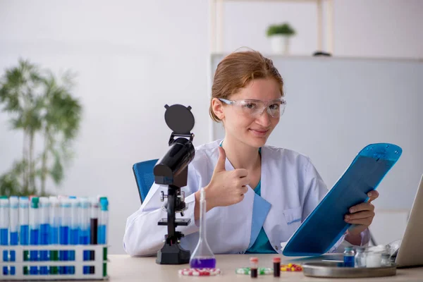 Jonge vrouwelijke chemicus in drugssynthese concept — Stockfoto