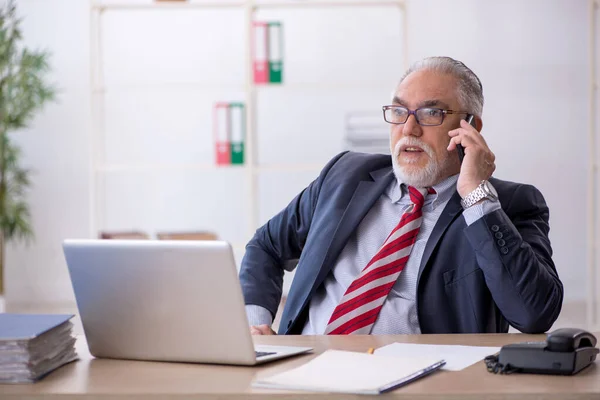 Ancien employé masculin travaillant dans le bureau — Photo