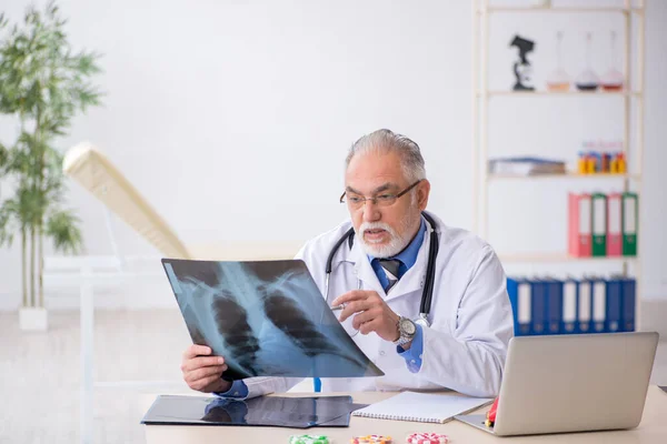 Klinikte çalışan yaşlı bir erkek radyolog. — Stok fotoğraf