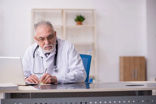 Klinikte çalışan yaşlı bir erkek radyolog. — Stok fotoğraf