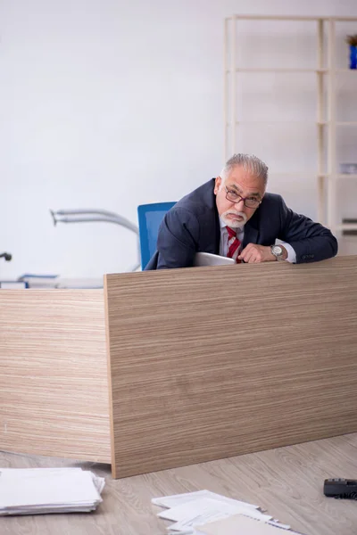 Gammal manlig anställd som arbetar övertid på kontoret — Stockfoto