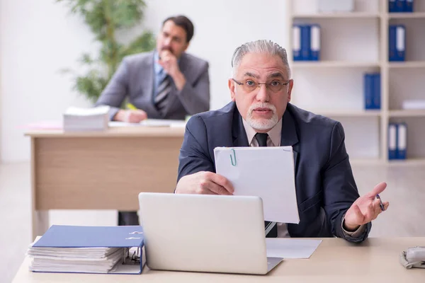 Twee mannelijke werknemers die op kantoor werken — Stockfoto