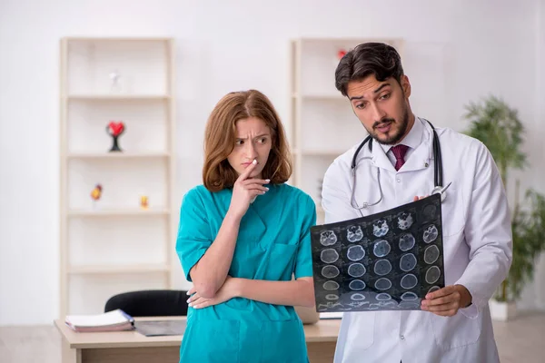 Jonge mannelijke arts radioloog en vrouwelijke assistent werkzaam in th — Stockfoto