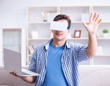 Evde sanal gerçeklik gözlükleriyle serbest çalışan bir öğrenci.