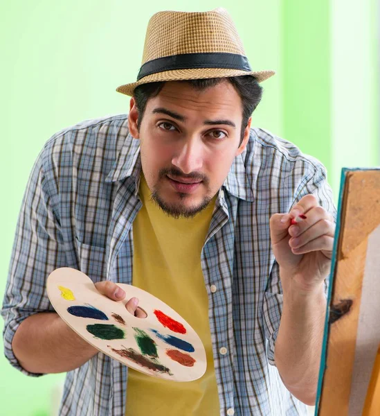 Joven artista masculino trabajando en una nueva pintura en su estudio — Foto de Stock
