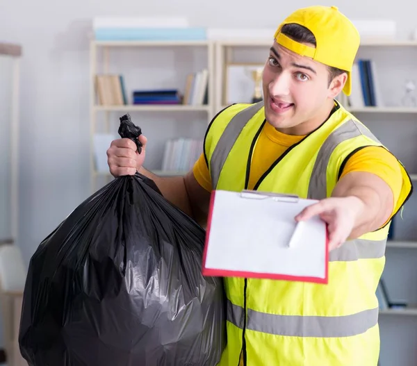 Homem limpando o escritório e segurando saco de lixo — Fotografia de Stock