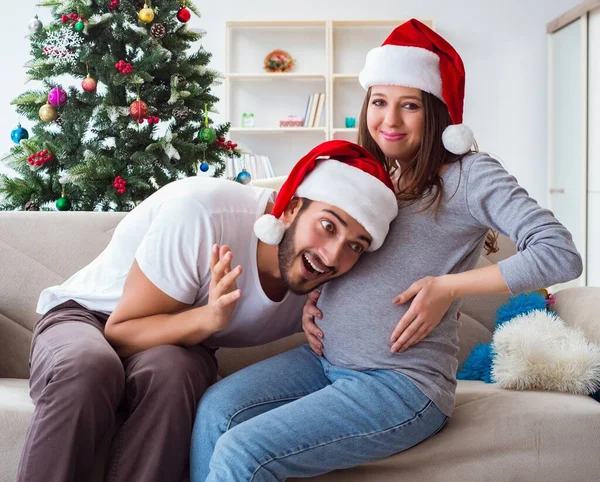 Genç aile Noel 'i kutlayan bir bebek bekliyor.