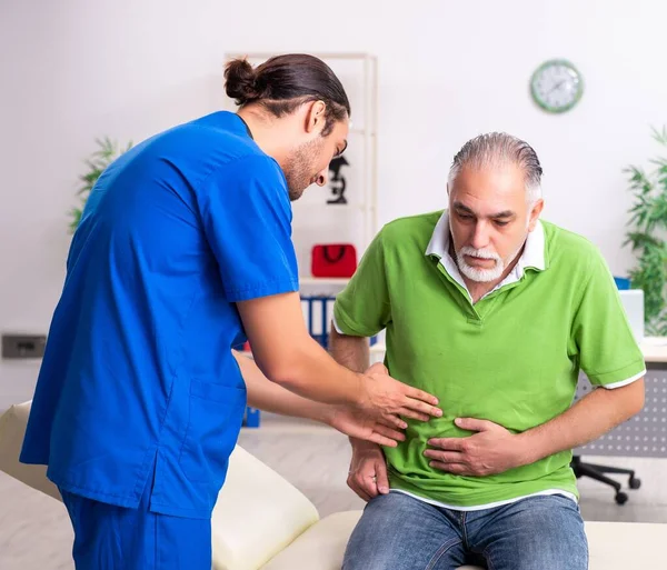 Gamle man besöker ung manlig läkare gastroenterolog — Stockfoto