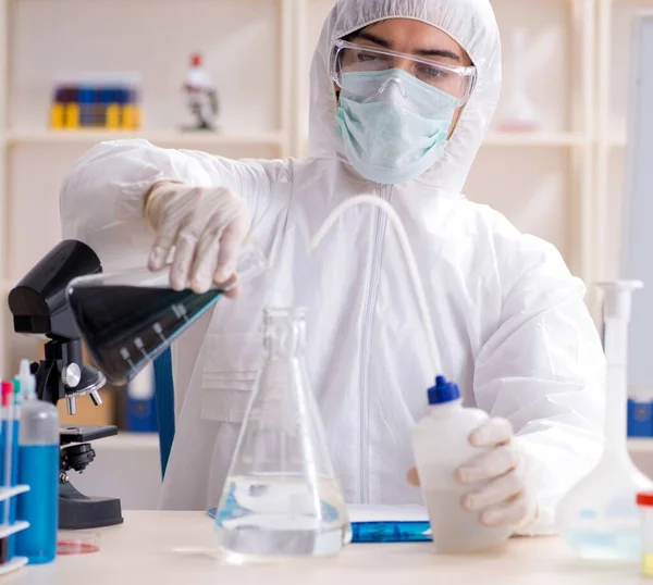 Laboratuvarda çalışan genç yakışıklı kimyager.