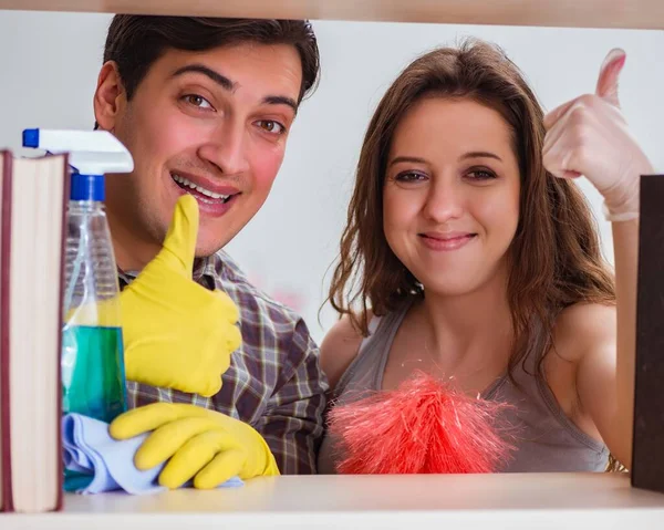 Esposa y marido limpiando polvo de la estantería — Foto de Stock