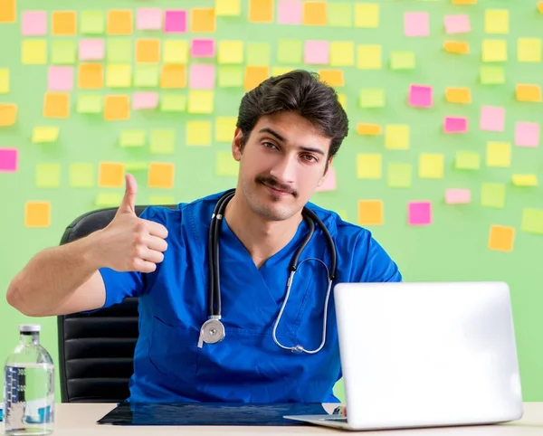 Médico joven con muchos recordatorios y trabajo urgente —  Fotos de Stock